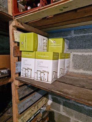 many boxes of wine sitting on a shelf in a room