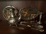 une théière en argent et des cuillères en argent posées sur une table