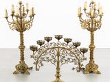 a set of four brass candelabs with candles on them
