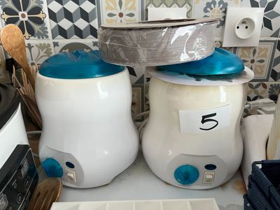 deux pots blancs et bleus posés sur un plan de travail, avec un couvercle bleu