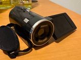 un appareil photo noir posé sur une table, à côté d'un téléphone portable
