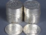 several stacks of silver coins sitting on top of each other on a table