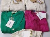 four sweaters are stacked on top of each other on a table