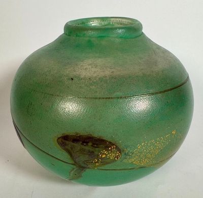 a green vase with a fish on it on a white surface