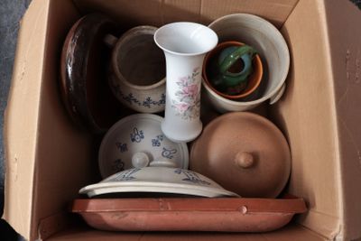 une boîte en carton remplie de différents types de vases et de bols