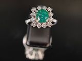 une bague en émeraude et diamant sur une surface noire