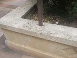 a concrete planter with a bird sitting on top of it