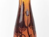 a brown and orange vase sitting on a black stand