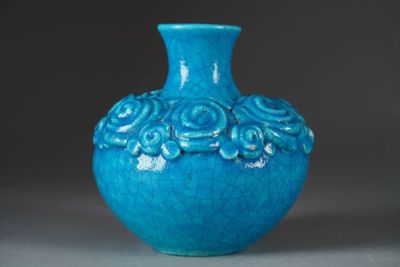 a blue vase with flowers on it sitting on a table