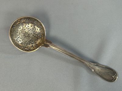 une cuillère en argent avec un manche de cuillère sur une table
