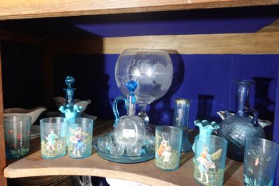 une étagère sur laquelle sont disposés de nombreux objets en verre
