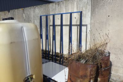 un grand réservoir jaune posé à côté d'un conteneur métallique