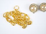 two pairs of earrings and a gold chain with pearls