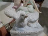 une figurine représentant une femme et un oiseau posée sur une boîte