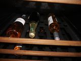 bottles of wine are sitting in a wine cooler in the dark