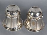 two silver salt and pepper shakers on a gray surface