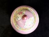 a pink bowl with a strawberry in it on a black surface