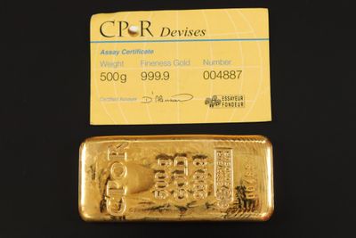 un lingot d'or et une carte de visite posés l'un à côté de l'autre