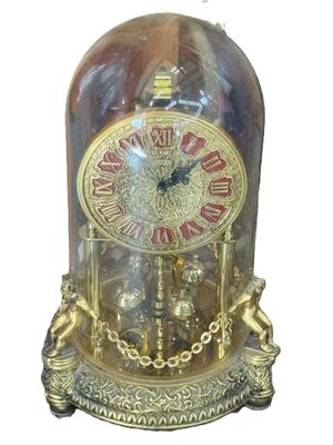 une horloge à l'intérieur d'un dôme en verre, entourée d'une chaîne
