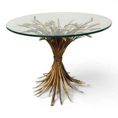 a round glass table with gold branches on top
