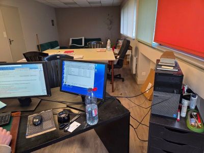 un homme assis à un bureau devant deux écrans d'ordinateur