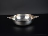 bol plaqué argent posé sur une table noire, sur fond noir