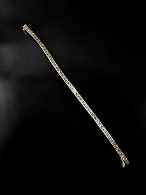 un gros plan d'un bracelet en or et diamants sur fond noir