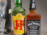 bottles of whiskey and a glass of water sit next to each other