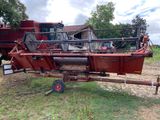 un gros tracteur rouge attelé à une remorque