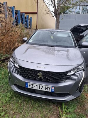 a grey car parked in front of a building next to another car
