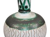 a green and white vase sitting on a white surface