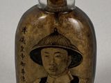 a small glass bottle with a picture of a woman on it