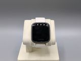 an apple watch is sitting on a white stand on a gray surface