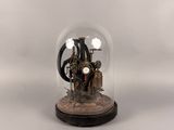 figurine of a steam engine under a glass dome on a wooden base