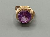 a close up of a ring with a purple stone in it
