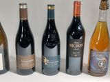 several bottles of wine are lined up on a white surface