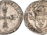 a silver coin with a cross on the front and a crown on the back