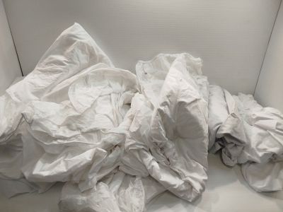 un canapé blanc recouvert d'un tas de draps blancs