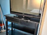 a television on a stand in the corner of a room