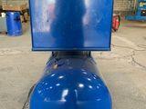 a blue tank sitting on top of a wooden pallet in a warehouse