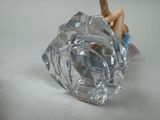 a figurine of a woman sitting on top of a glass object