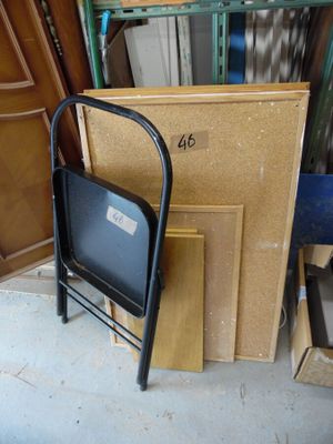 une chaise noire posée devant une pile de bois
