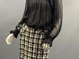 an image of a mannequin dress with a black blouse and plaid skirt