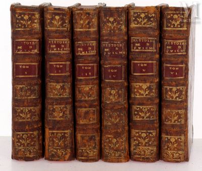 six vieux livres sont alignés sur une table