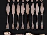 a lot of silver spoons and forks on a black background