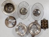 a lot of silver dishes and pans sitting on a table