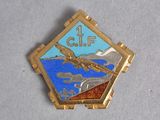 a gold and blue pin with a bird on it