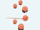 an image of a group of coral colored beads and a wooden stick