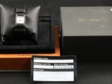 une boîte contenant une montre, à laquelle est jointe une carte