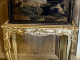 une table noire et dorée surmontée d'un miroir